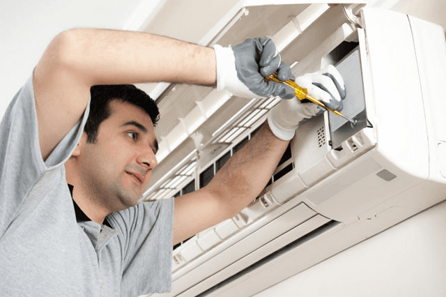 Technician servicing AC unit